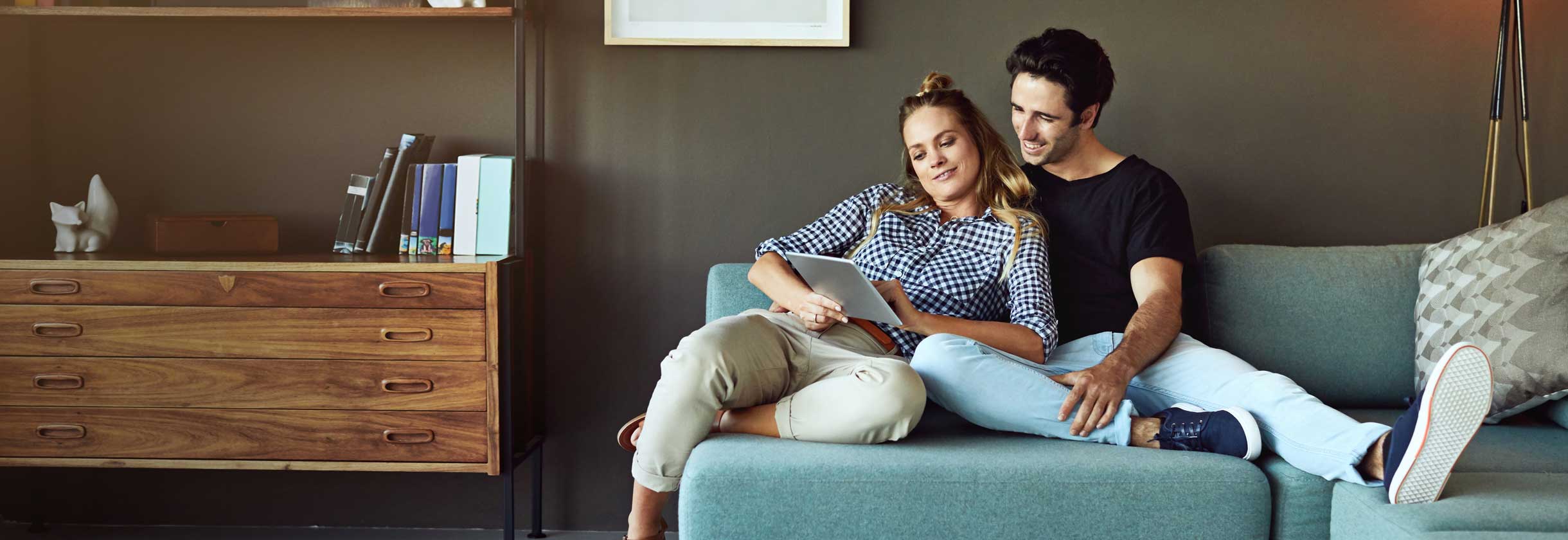 People sitting on couch using Billpay on tablet